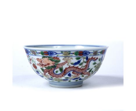 Wucai porcelain bowl Chinese, 19th Century the centre painted  with a dragon chasing flaming pearls, the sides of the bowl pa