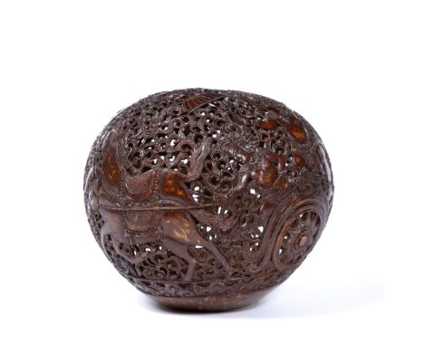 Carved coconut lamp Balinese carved with foliate scrolls and deities. 18cm across