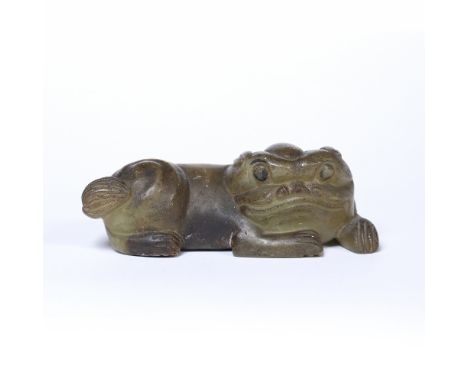 Black tinted greyish green hardstone boulder Chinese carved in a simplified Tang style as a recumbent Buddhist lion looking o