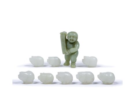 Nine jade pendants Chinese each carved in the form of a pig 3.5cm across  and a carved jade boy holding open a scroll. 7.25cm