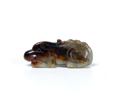 Striated jade carved pendant Chinese, 18th Century in the form of a crouched temple dog carved in the Ming style 5.75cm long