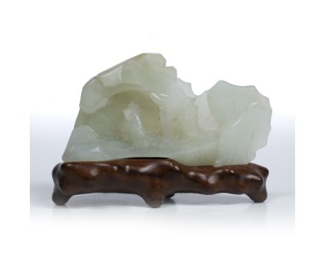 White jade pebble Chinese 19th Century carved as a mountain with a traveller on a path approaching a cave within which an Imm