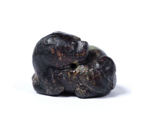 Black and grey mottled jade pebble pendant Chinese carved as a recumbent Buddhist lion looking back over its left shoulder 4c