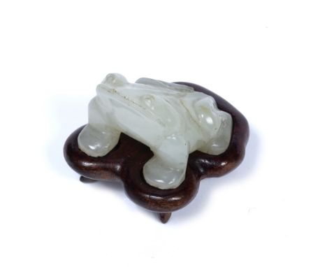 White miniature jade pebble  Chinese carved as a squatting four legged toad, on fitted wood stand