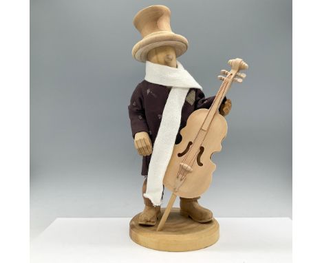 This nutcracker features a polished finish, dressed in a dark brown coat, a white scarf and light brown trousers, holds a fin