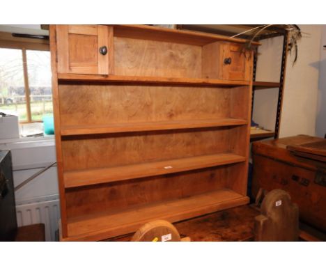 A pine open bookcase, fitted two cupboards, 44" wide, and a stripped pine open seven-tier wall shelf, 29" wide