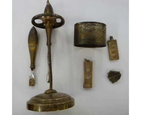 Silver items, viz. two similar ingot pendants; an engine turned oval napkin ring; a manicure implement stand; and Mizpah broo