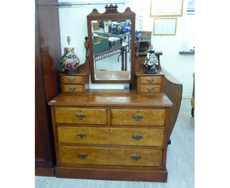 An Edwardian walnut dressing table, surmounted by a pivoting bevelled mirror, over four box drawers and two short/two long dr