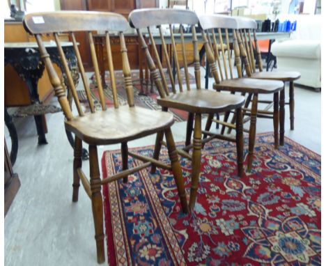A set of four early/mid 20thC beech and elm framed dining chairs, each with a curved crest and spindle back, the curved solid