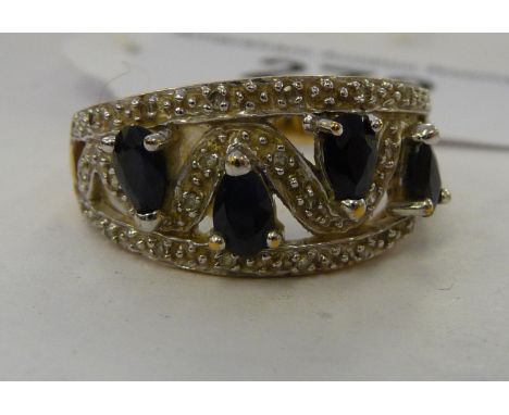 A 9ct gold four stone sapphire ring, in a diamond encrusted zigzag setting       11