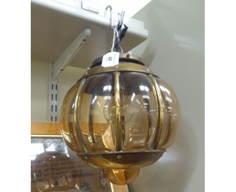 A mid 20thC brass pendant lamp with blown, tinted amber glass shade       TO9