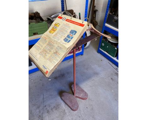 A 1960s garage workshop metal stand with a quantity of Esso service guides, lubrication charts etc.