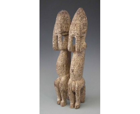 Pair of Dogon figures carved covering their eyes, 33cm high     All lots in this Tribal and African Art Sale are sold subject