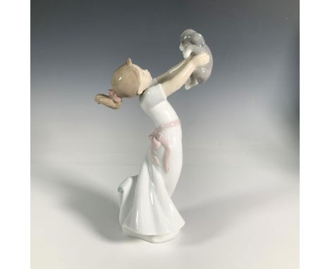 A sweet, glossy ceramic figure depicting a girl lovingly gazing at her puppy while holding it up. Lladro backstamp. Artist: J