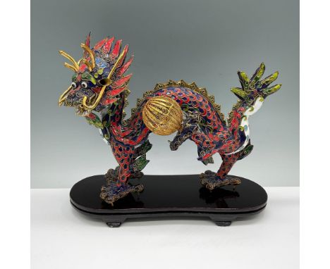 An intricate gilded brass and polychrome enamel Chinese dragon holding a large gilt wire ball, which represents a pearl. In C