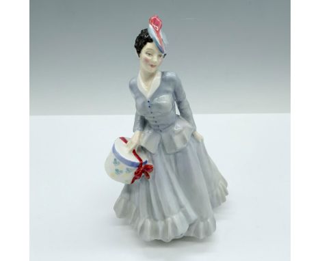 Handmade and hand decorated glossy figure from the Harradine Classics Series that depicts a woman modeling a light blue skirt