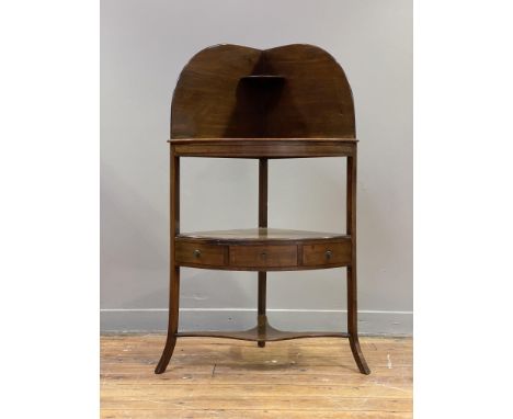 A Georgian mahogany corner washstand, the raised back with open shelf above bow front fitted with a drawer, raised on square 