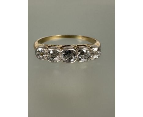 An Edwardian yellow and white metal colette set five stone old mine cut graduated diamond ring N/O 2.53g&nbsp;