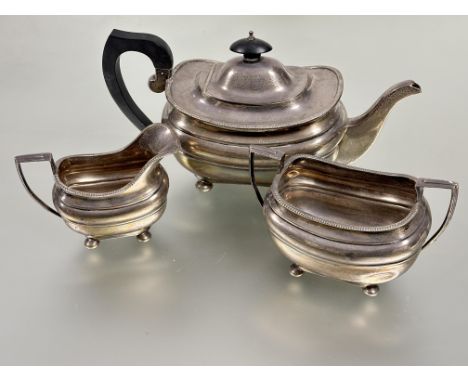 A Birmingham silver three piece tea service of oval lobbed design with gadroon border comprising tea pot with ebonized handle