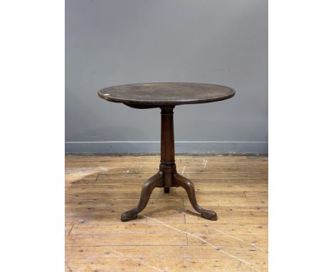 A George III mahogany tripod table, the single plank circular tilt top raised on a ring turned column and triple splay suppor