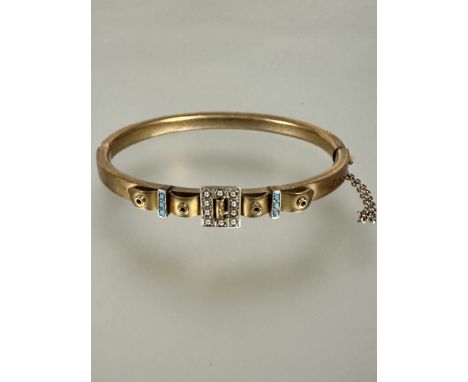 A Edwardian 9ct gold burnished gold stiff hinged bangle of buckle style form set half seed pearl panel flanked by bar set thr