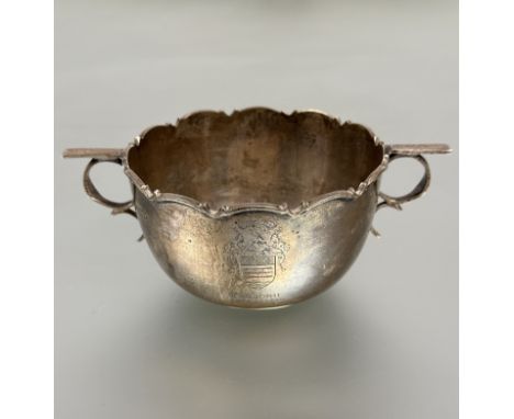 A Sheffield silver two handled porringer with scalloped top and ring scroll handles to side and engraved family crest and ins