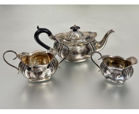 An&nbsp; Edwardian Sheffield siver three piece individual tea service of scalloped fluted panel design comprising ebony handl