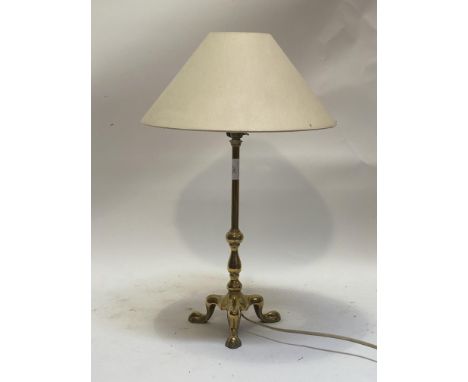 An early 20th century brass table lamp with paw cast tripod base. H54cm.&nbsp;