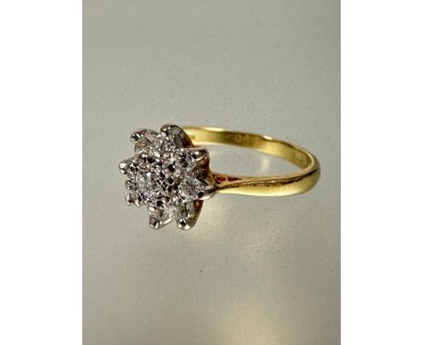 A 18ct gold diamond cluster ring the central brilliant cut stone approximately 0.10ct with surround of eight diamond points O