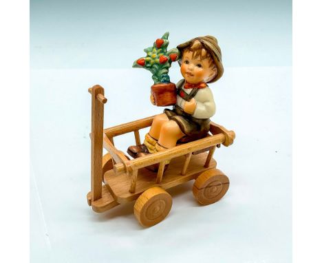 Hand painted porcelain figure of a young boy holding a potted plant. Includes a wooden wagon. Goebel backstamp. Figurine: 3.2