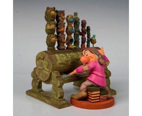 Snow White and the Seven Dwarfs sculpture of Grumpy dwarf seated on books playing a forest pipe organ. With original box whic