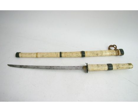 A Japanese bone Katana, the scabbard with carved warrior, a/f, and an Indian type white metal mounted stick