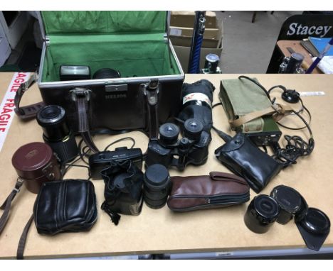 A collection of cameras and associated equipment including lenses together with binoculars and an amplifier.