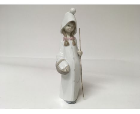 A Lladro figure of a girl holding a basket and a loose stick