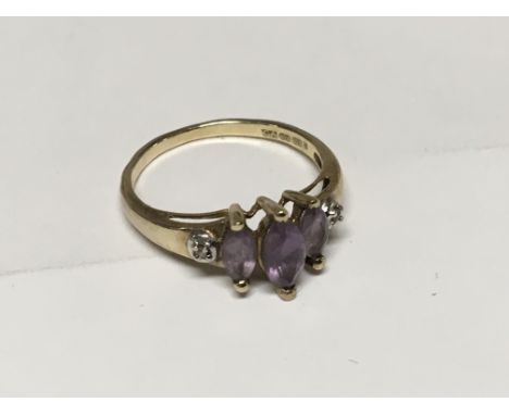 An Amethyst and diamond lady’s ring with three graduating stones flanked by diamonds. Set in 9ct Gold Ring size Q.