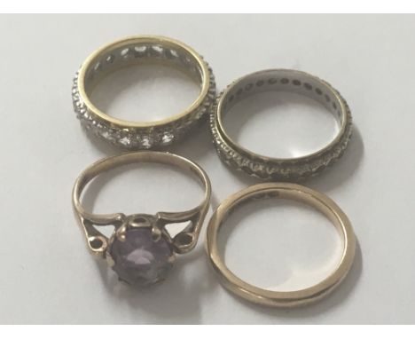 A 9ct Gold wedding ring one other 9ct Gold ring set with an amethyst, and two eternity rings. (4)