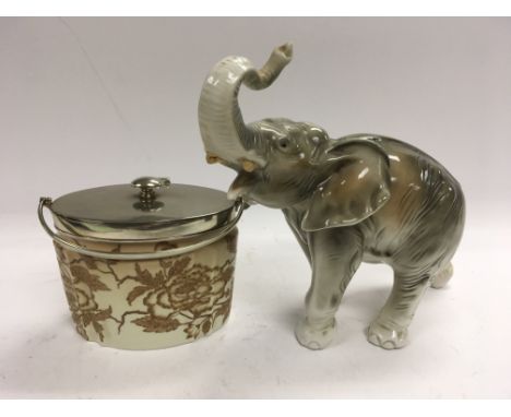 A ceramic elephant figure together with a tobacco jar.