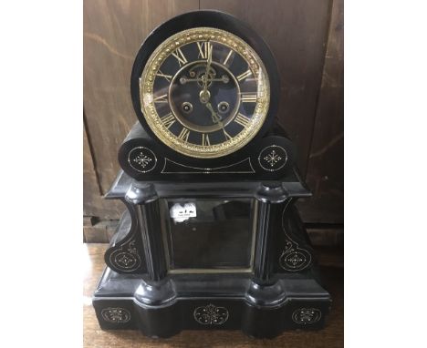 A large Victorian slate mantle clock of rounded form with open brass skeleton dial