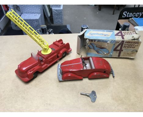 A boxed Toby mechanical coupe together with a toy fire engine.