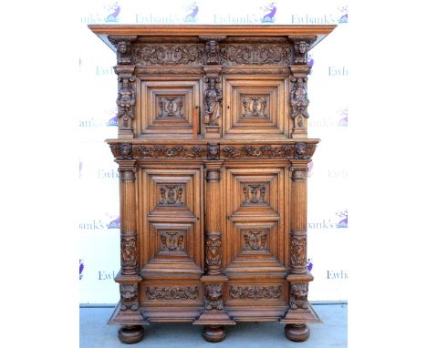 Late 19th century Flemish oak armoire carved with figures and hunting scenes, top with two cupboard doors, base with two cupb
