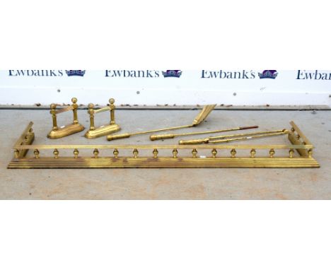A Victorian style brass fender, with pillared supports and stepped kerb, 144cm long, a matching pair of andirons, and a set o