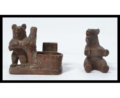 Two Blackforest Black Forest carved figurines of bears one in the form of an inkwell holder the other in a seated position.