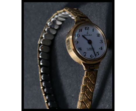 A ladies cocktail 9ct gold hallmarked&nbsp; wristwatch, Excalibur to the enamel face set to an gilt expandable bracelet.