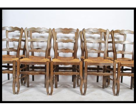 A set of 10 French provincial oak ladderback dining chairs being raised on serpentine legs with rattan weave seats and wavey 