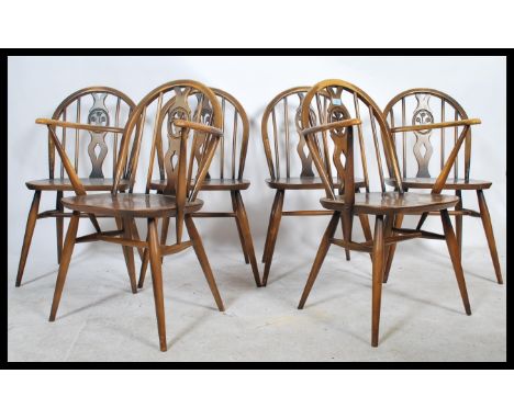 A set of six vintage mid 20th Century Ercol hoop back beech and elm dining chairs to include two carvers. Fleur De Lys splat 