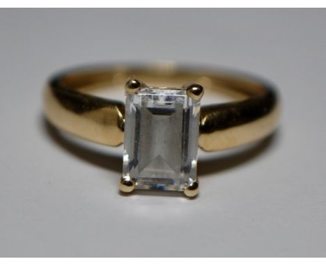 A hallmarked 14ct gold ring having a large emerald cut white stone. Weighs 2.1 grams size I.5