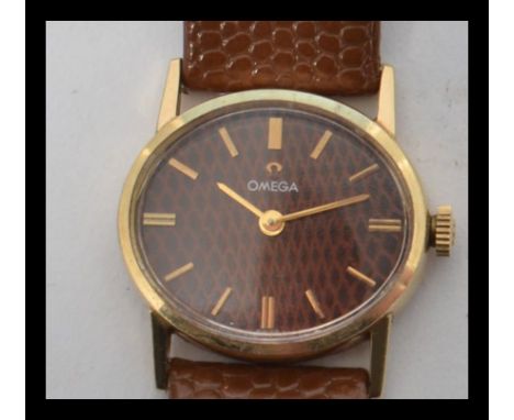 A 14ct gold cased Omega watch of oval form having a Moroccan leather / snakeskin effect dial with baton numerals and gilt fac