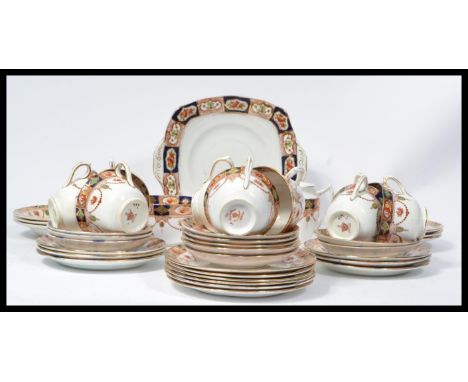 An early 20th century Royal Albert tea service in an Imari pattern consisting of cups , saucers , side plates , milk creamer 