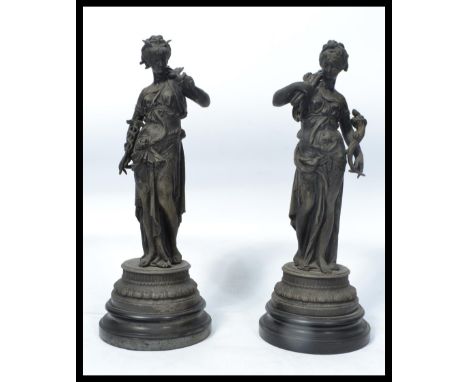 A pair of 19th century classical spelter figurines, each with maiden playing musical instruments being raised on wooden plint