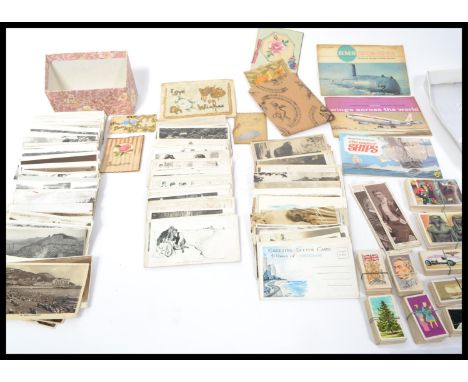 A collection of vintage postcards dating from the early 20th century together with a small quantity of cigarette / tea cards.